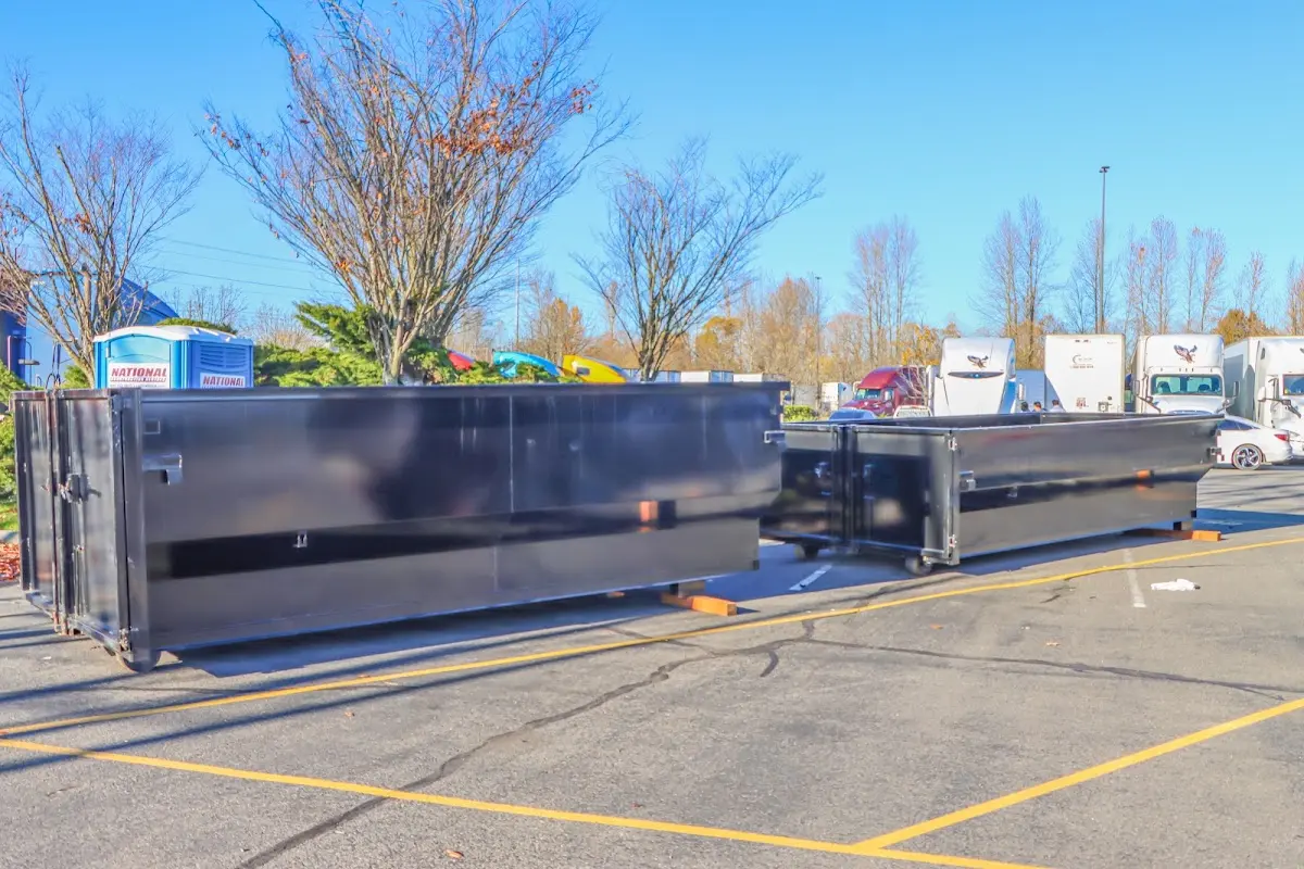 Professional dumpster rental service with roll-off container on residential driveway in Neosho